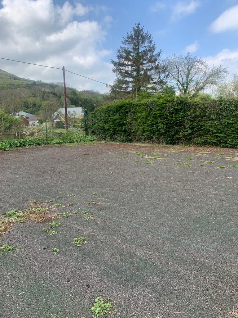 This is a photo of a tennis court in Dorset that is in need of refurbishment