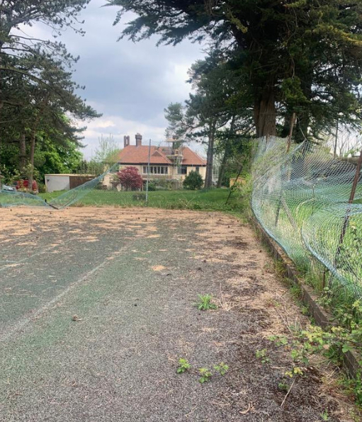 This is a photo of a tennis court in Dorset that is in need of refurbishment